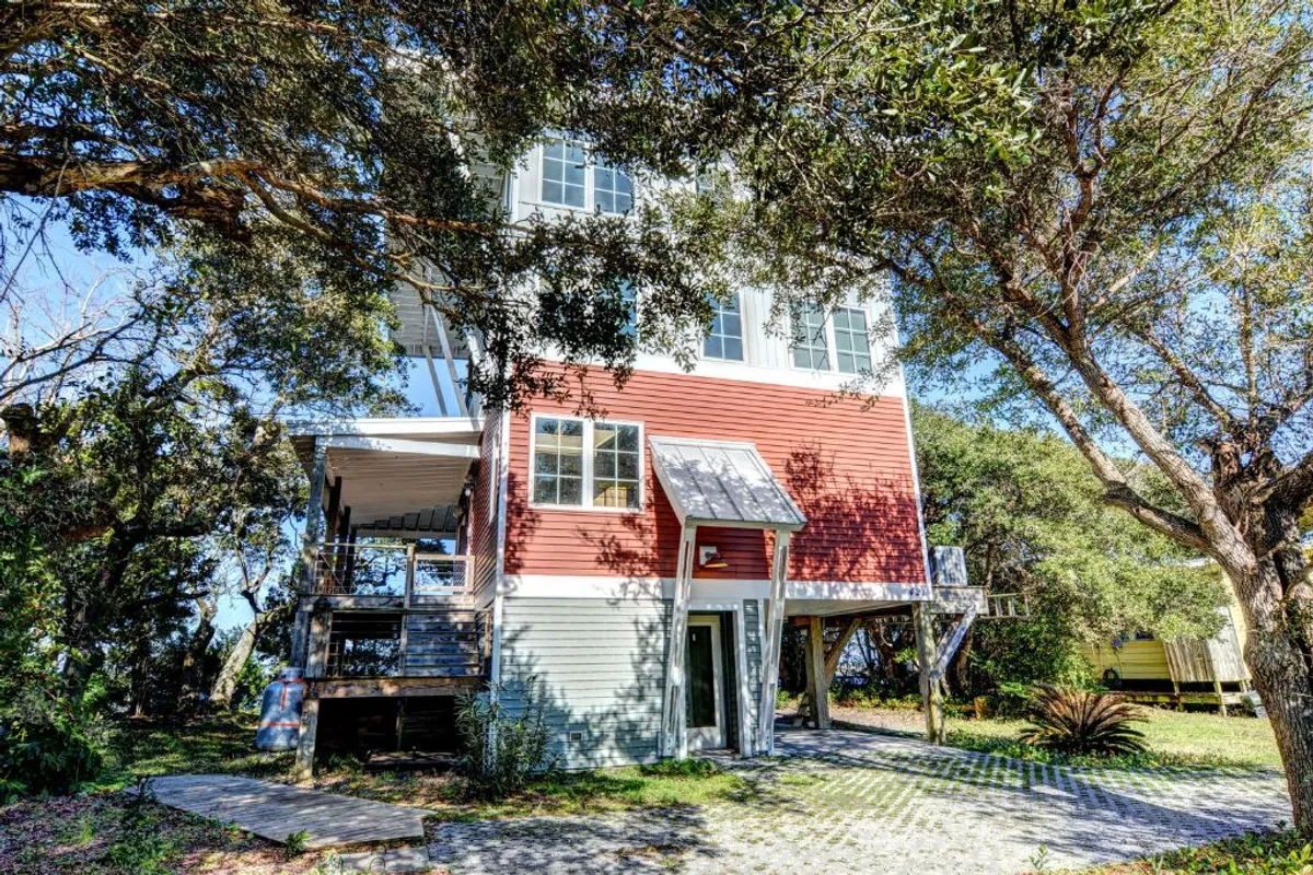 The distinctive red exterior of The Nancy Ann stands elevated with expansive decks and large windows. The deck area beckons for relaxation after a day’s adventure, with ample space for family gatherings and scenic views.