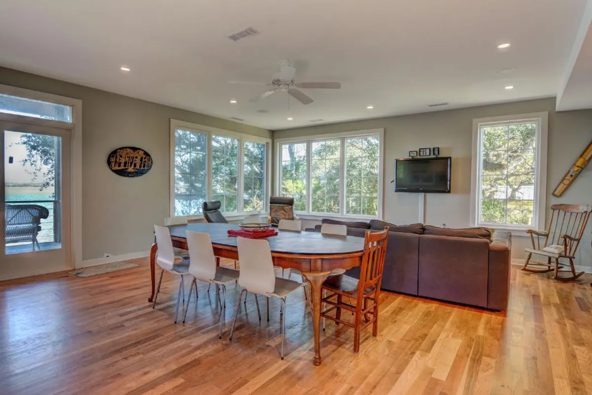 A spacious dining area with a large table and comfortable seating is showcased, with windows framing views of the outdoors. The setting is ideal for group meals, celebrations, and evening board games, encouraging guests to come together and make memories in a relaxed, friendly space.